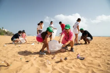Group of people picking up trash on the beach