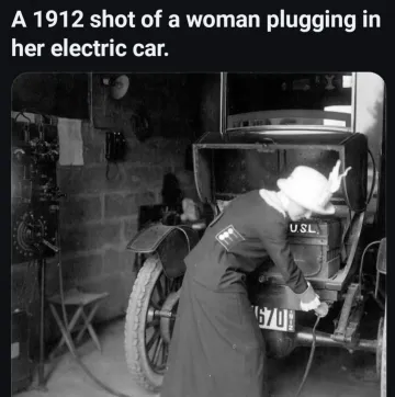 A 1912 shot of a woman plugging in her electric car.