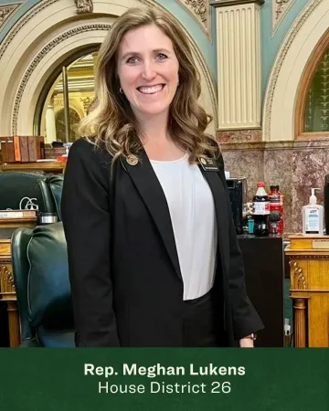Headshot of Meghan Lukens in front of the State House chambers 