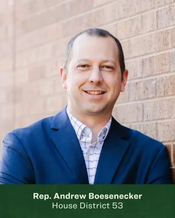 Headshot of Andrew Boesenecker in front of a brick wall 