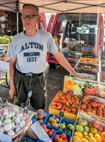 Clifford Clark stands under a tent at the farmer's market.