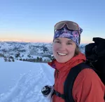 smiling woman in ski gear on snowy hill
