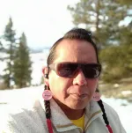 Picture of a man with snow and trees in the background
