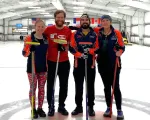 Greyson Norcross stands with fellow curling team members on an ice rink