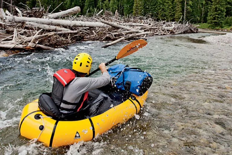 Greg Peters paddles with gusto to avoid being swept under a massive log pile on the Flathead River. | Photo by Aaron Teasdale