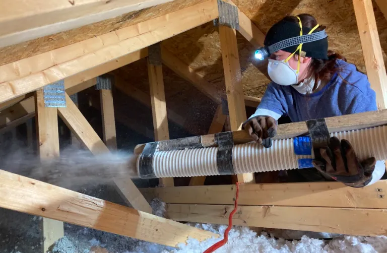COA student Celia Morton insulates an attic, photo by David Gibson