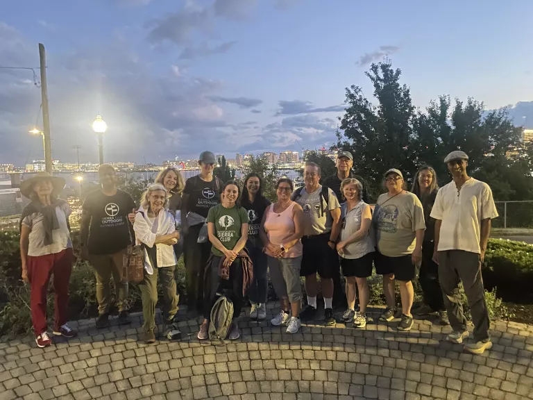 A group of people standing in East Boston with the harbor behind them