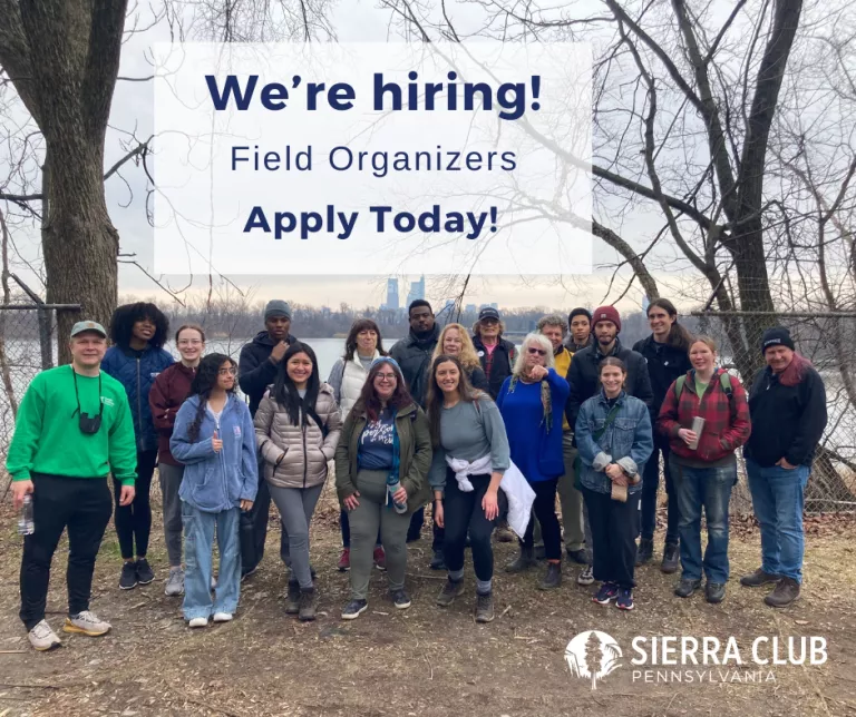 A diverse group of hikers pose for a photo in front of a reservoir surrounded by trees. Navy text announces, "We're hiring! Field Organizers Apply Torday!" with Sierra Club Pennsylvania's logo at the bottom.