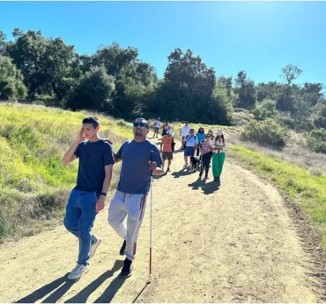 Several visually impaired people hiking with sight guides