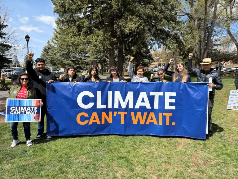a group of people holding a large blue banner