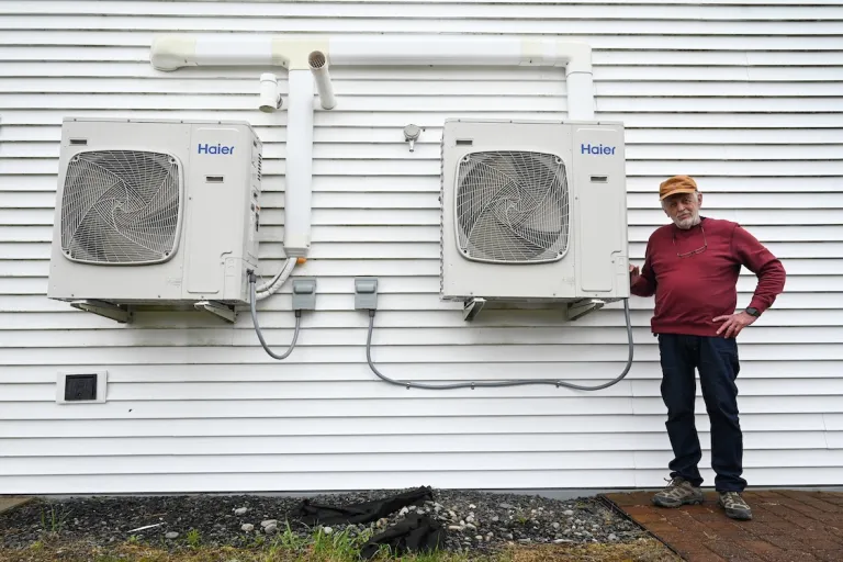 Dave Whittemore stands next to two heat pump units attached to the training facility. Photo by Kristian Moravec.