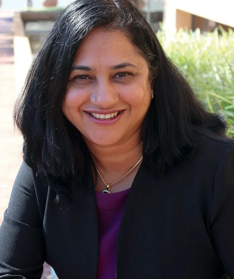Portrait of Shruti Bhatnagar smiling at the camera.