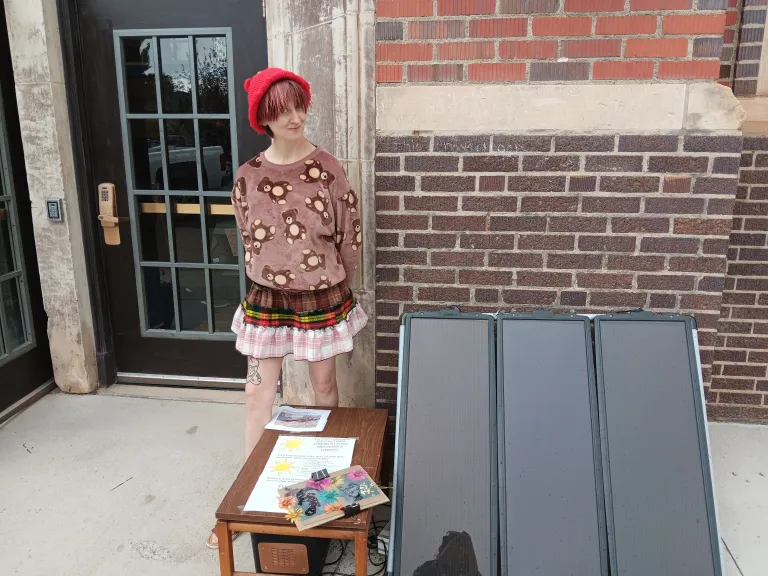 A person standing beside a solar panel
