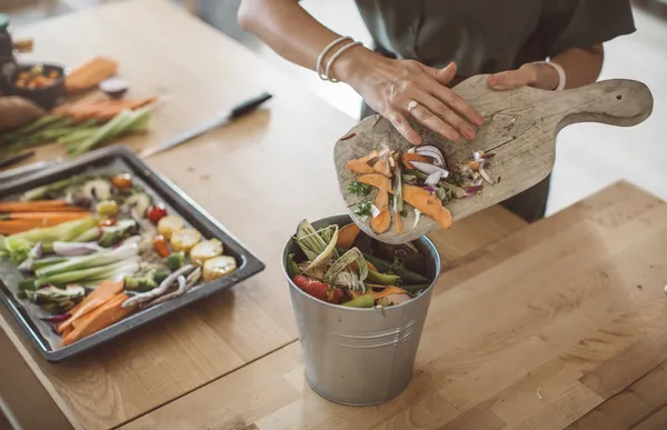 Vegetable scraps being put into a compost container