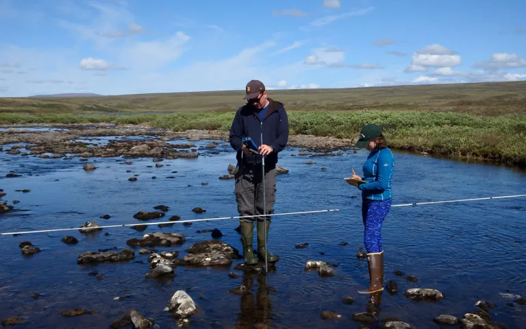Lab manager Jason Dobkowski and research technician Em Daily measure discharge at the Toolik Lake outlet. Toolik Field Station, Alaska.