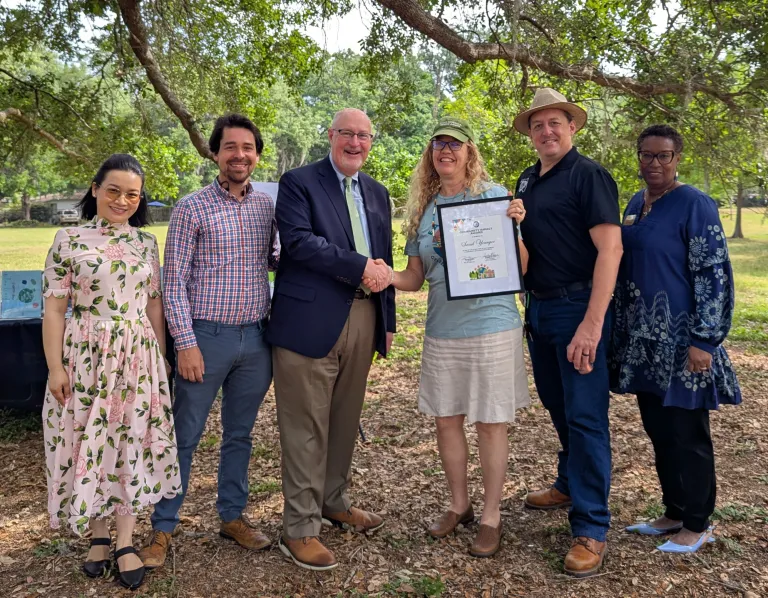 Sarah Younger receiving the Environmental Community Impact award from Gainesville city leaders on Earth Day 2025