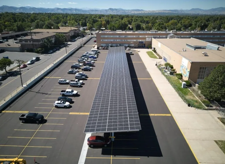 Picture of solar panels over a carport in a high school parking lot in Denver 