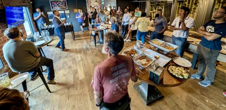 Image of transit activists listening to a guest speaker at a restaurant