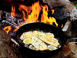 trout cooking over a fire