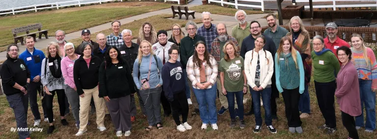 A large group of NC Sierra Club volunteers pose for a photo on a grassy lawn