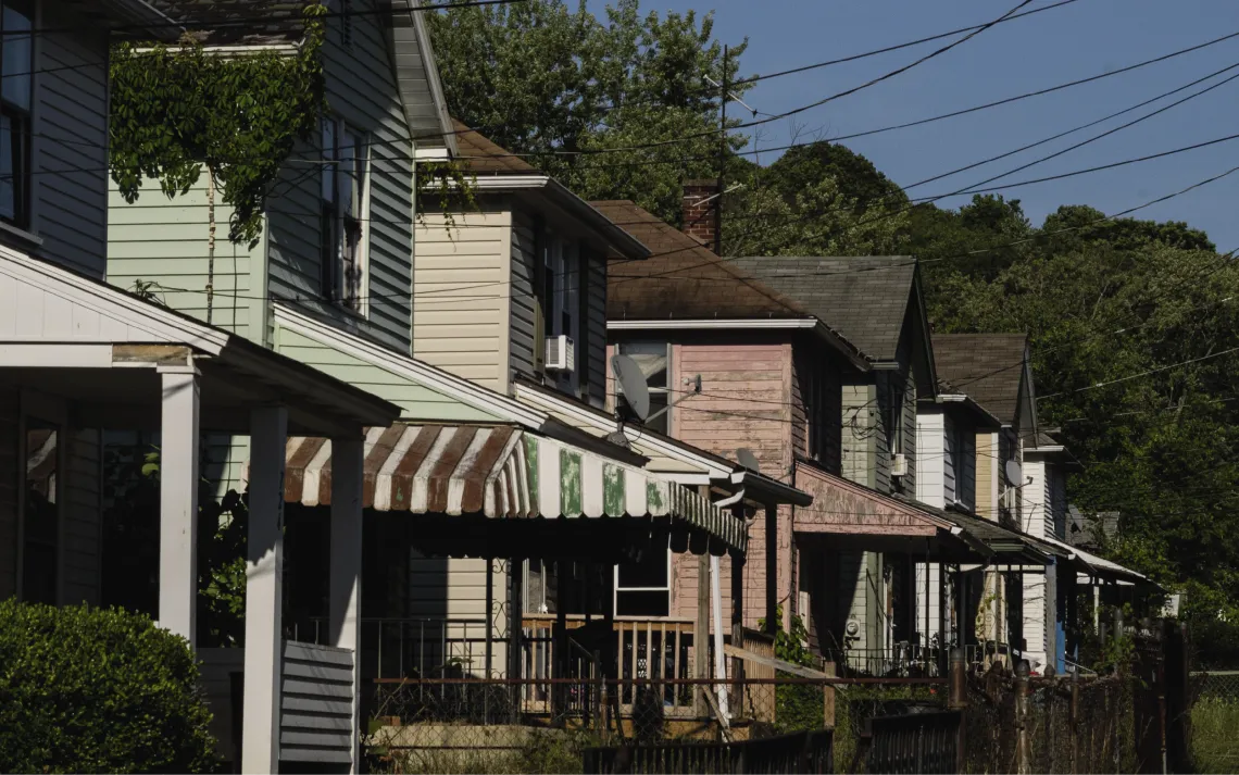 Side view of a row of slightly dilapidated houses.