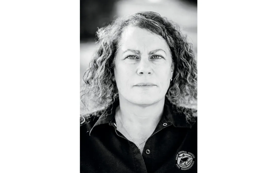 Riva Duncan has curly brown hair and looks at the camera with a serious expression.