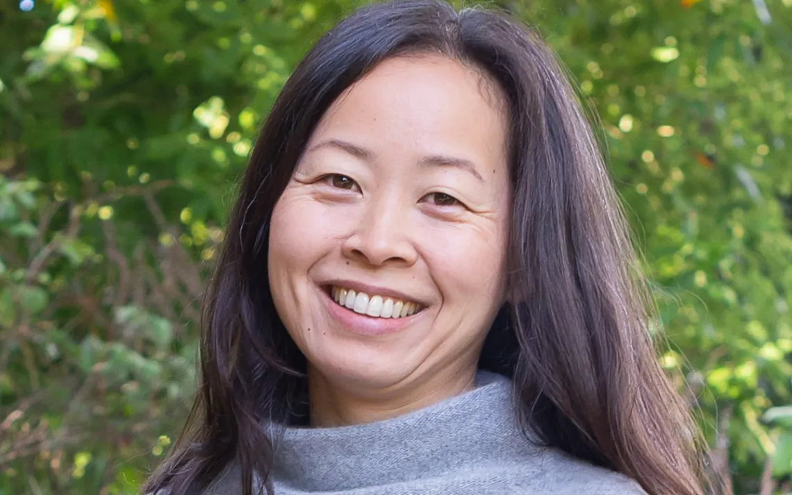 Photo of Helena Choi in a green, leafy landscape. 