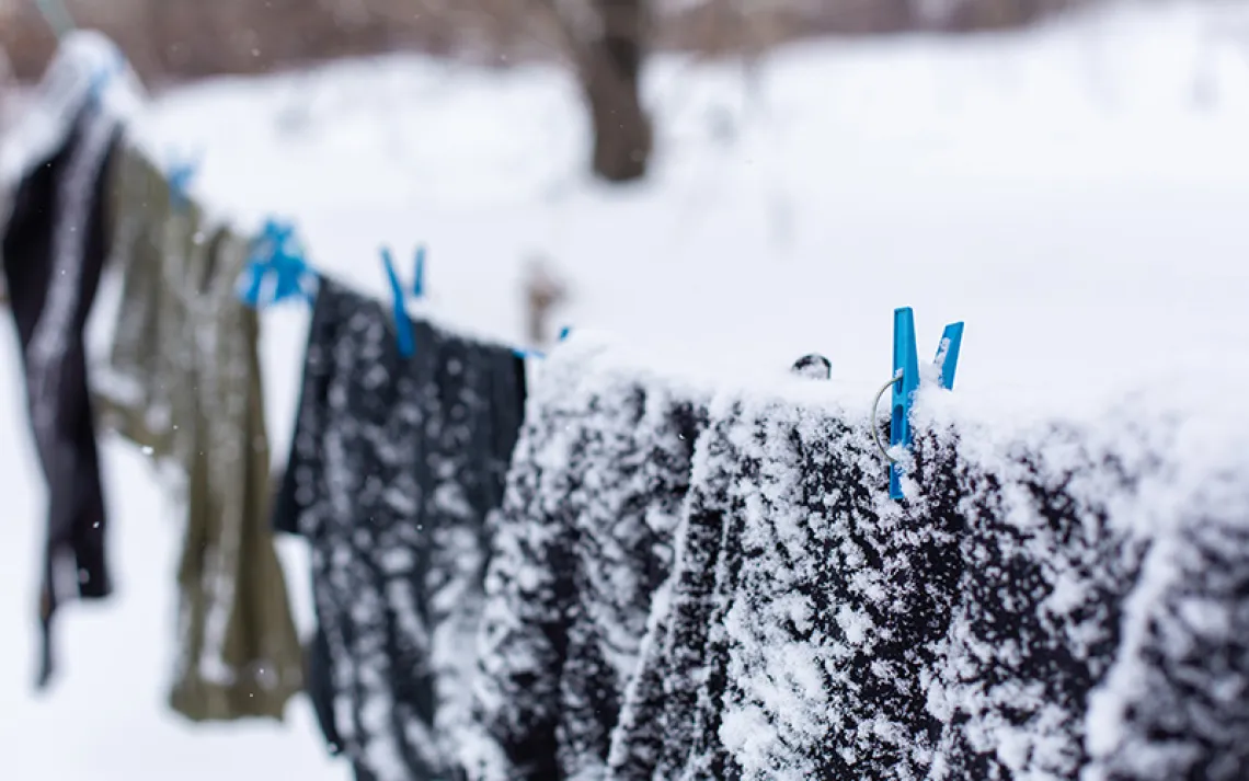Snow-covered clothes on a clothesline. Photo by Kateryna Kukota | iStock.