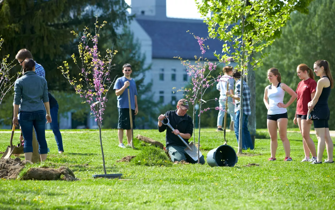 Students participate in a tree-planting event for Arbor Day at Middlebury College.