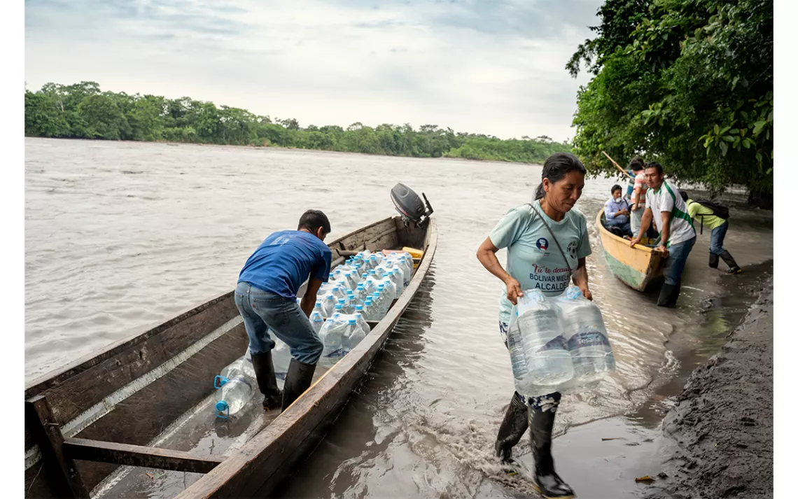 Indigenous community members carry water packs in the wake of the oil spill affecting their river and territory, northern Ecuadorian Amazon, April 18, 2020. 
