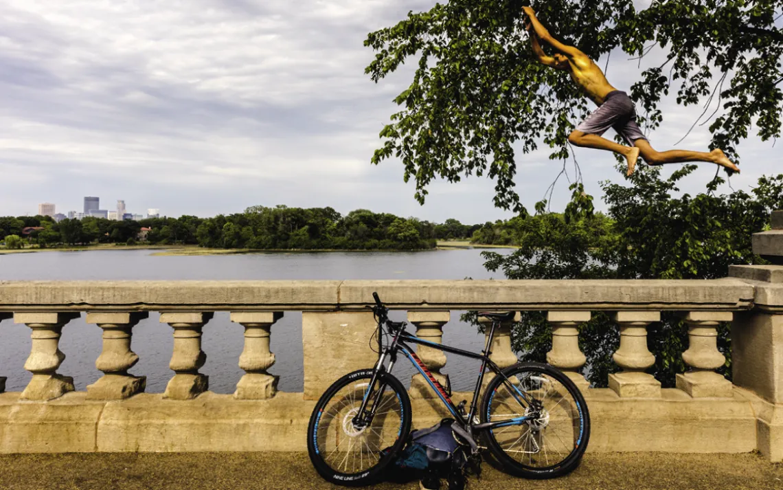 Samir Ouenniche jumps into Lake of the Isles. 
