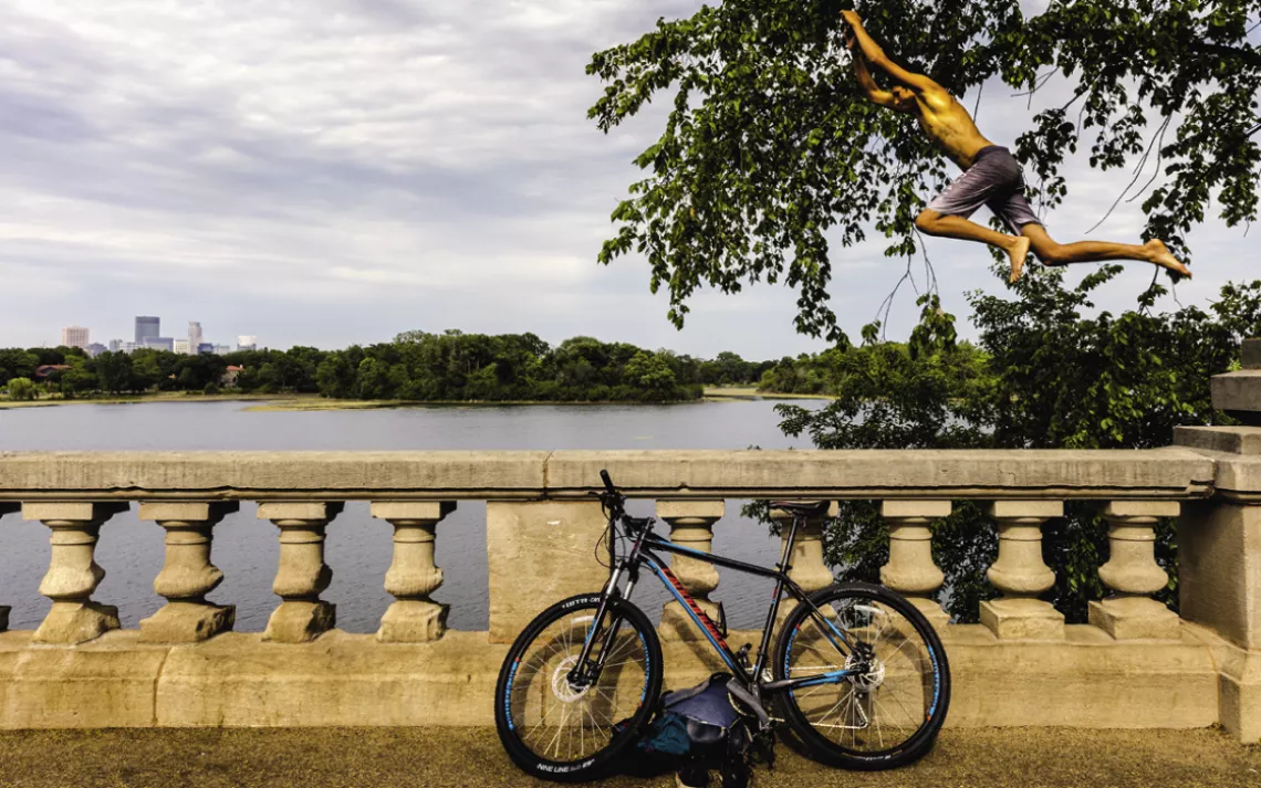 Samir Ouenniche jumps into Lake of the Isles. 
