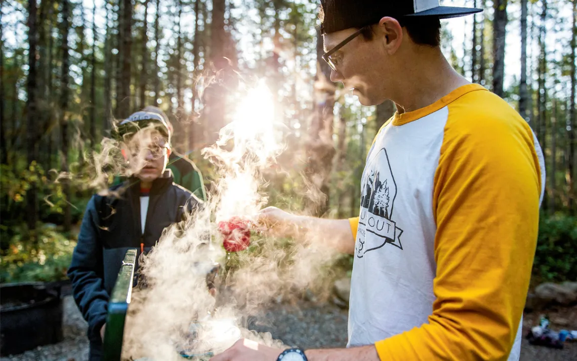 Travis Clough cooks English-muffin pizzas at the Big Creek Campground
