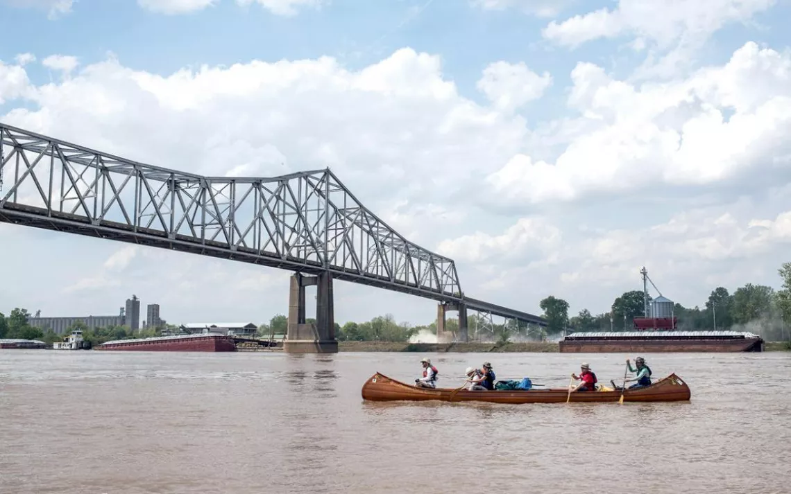 Paddling a handmade canoe under a bridge in Helena, Arkansas, en route from St. Louis to the mouth of the Mississippi.