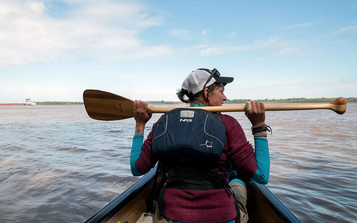 Guide Lena von Machui waits for barge traffic to pass on the Mississippi River.