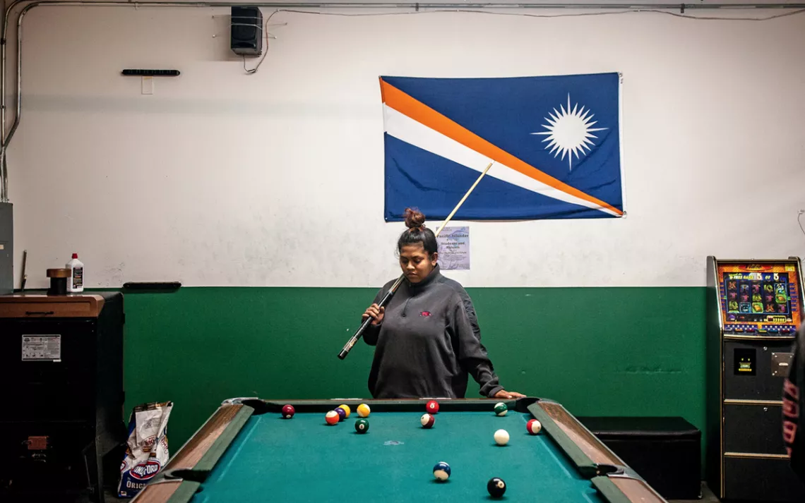 Jelly Laikidrik plays pool in the back of her parents' local business.