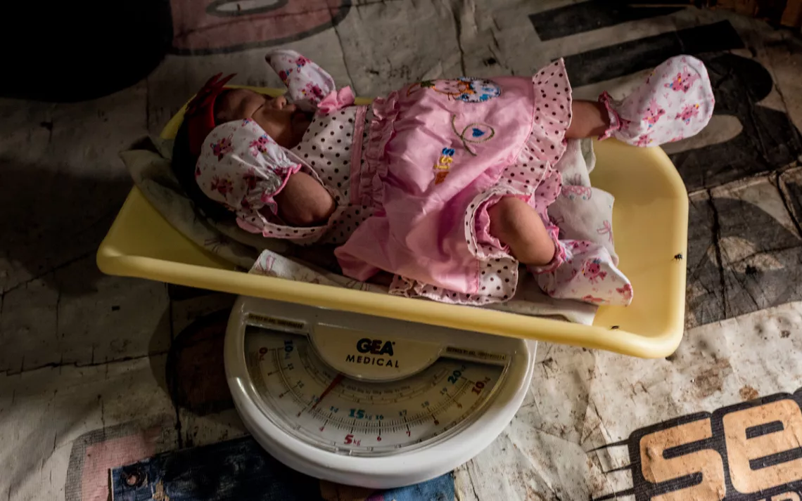 Muji weighs a baby girl.