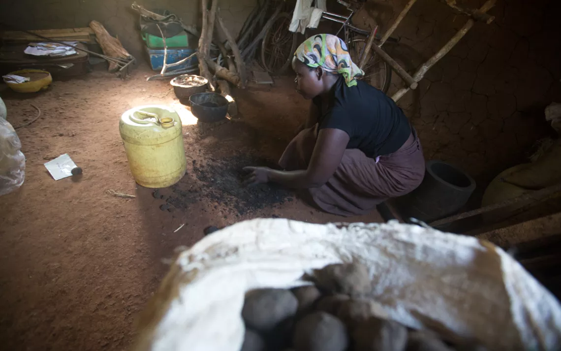 Amayo, making charcoal briquettes in her hut. 