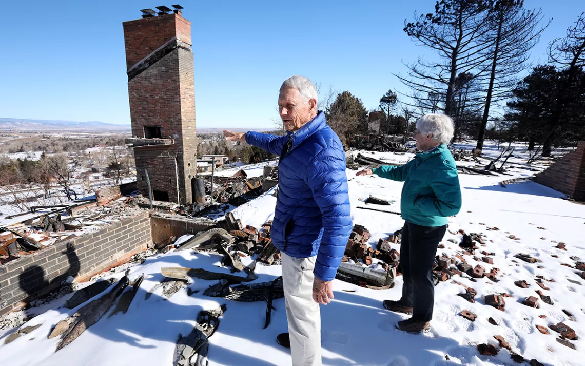 Jon and Elizabeth Hinebauch stand near what is left of their home after the Marshall Fire.