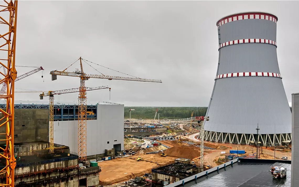 Construction of a nuclear power plant. Tower cranes on the background of the cooling tower.