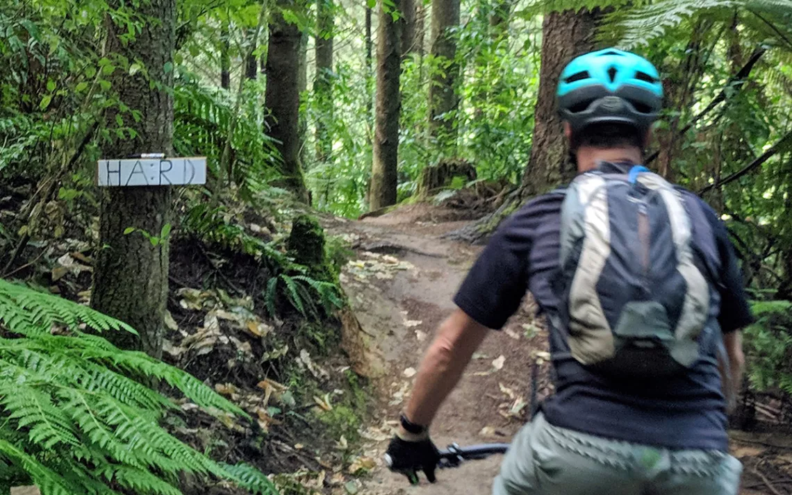 Mountain bike trail with a sign that says 'Hard'