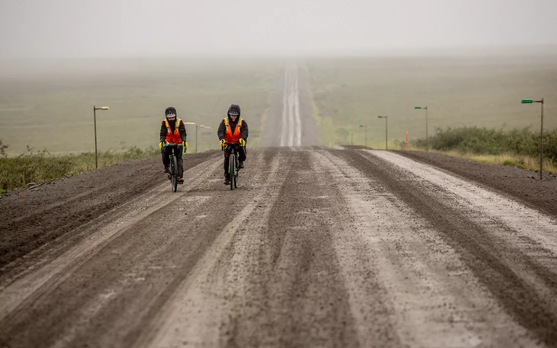 Brooke and Kailey ride through a foggy Arctic, wearing vests tossed to them by truck drivers.