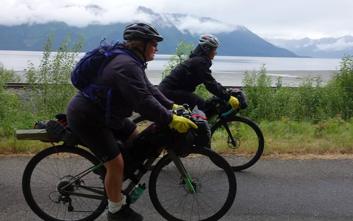 Brooke and Kailey pedal along the Seward Highway towards Anchorage.