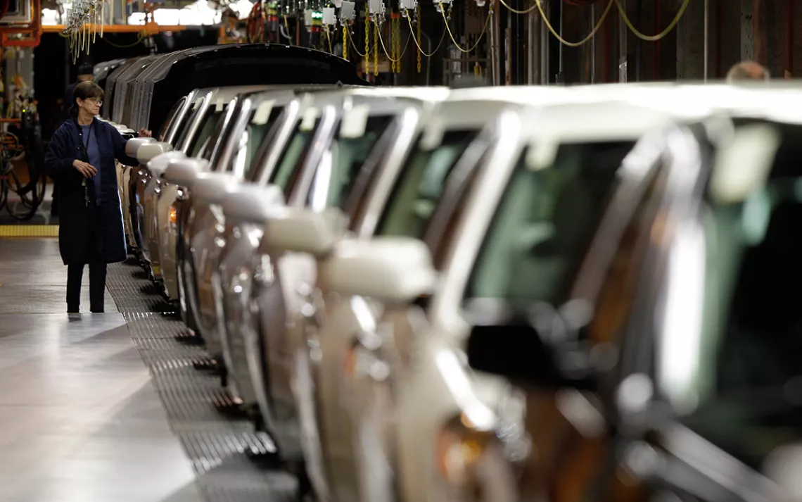 A line worker checks vehicles at the General Motors Hamtramck assembly plant in Hamtramck, Mich.