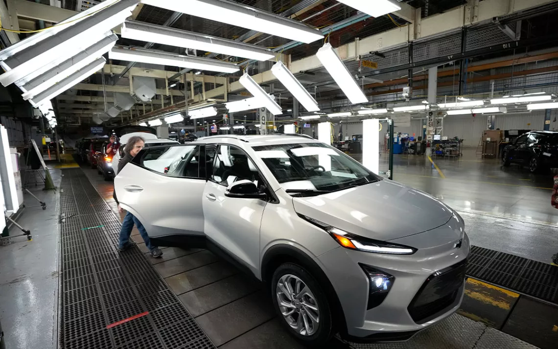 An assembly line worker looks over a 2023 Chevrolet Bolt EUV