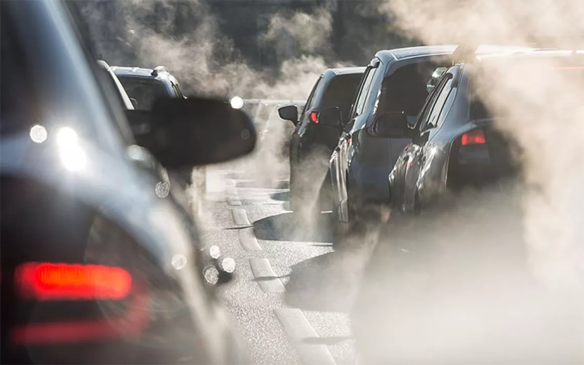 Blurred silhouettes of cars surrounded by steam from the exhaust pipes