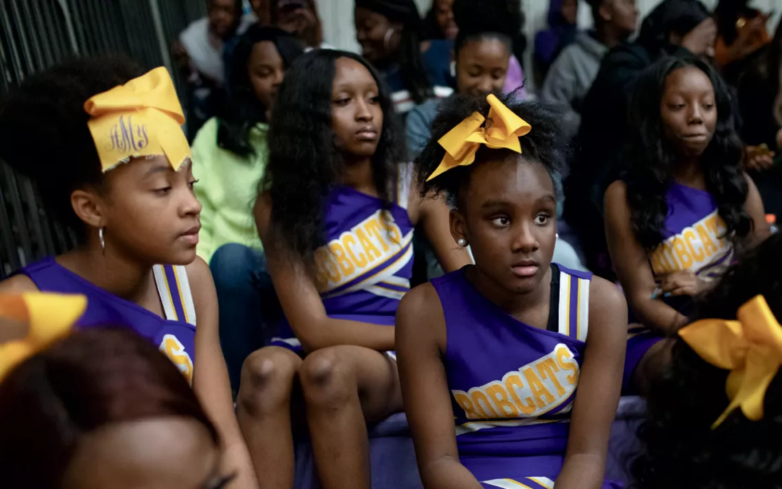 Cheerleaders for the Bobcats at Robert C. Hatch High School watch a basketball game.