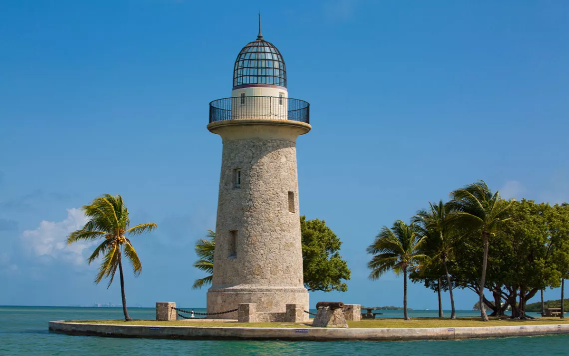 A lighthouse and palm trees by the water in Florida's Biscayne National Park