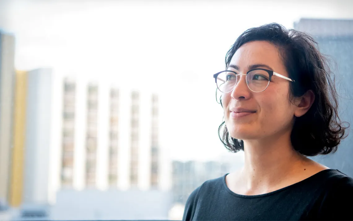 Rose Abramoff wears glasses and a black top and smiles, looking off to her right