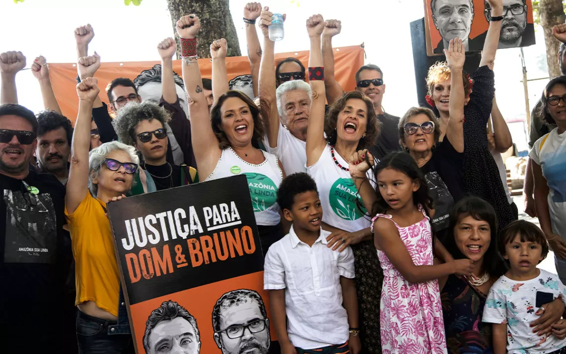 Activists raise their fists and hold a sign